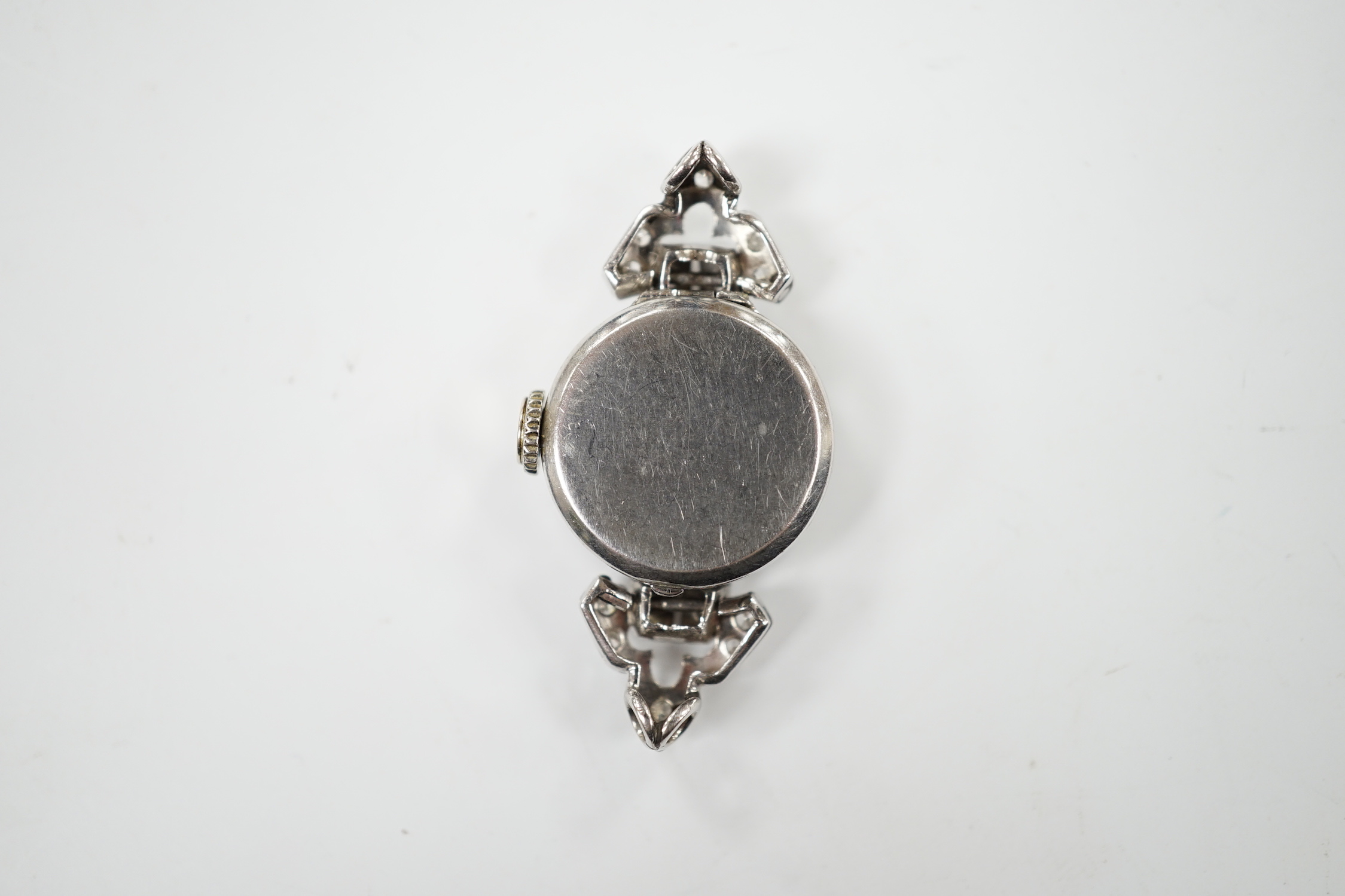 A mid 20th century white metal (inscribed platinum) and diamond cluster set Albion manual wind cocktail watch, no strap, gross weight 10 grams.
